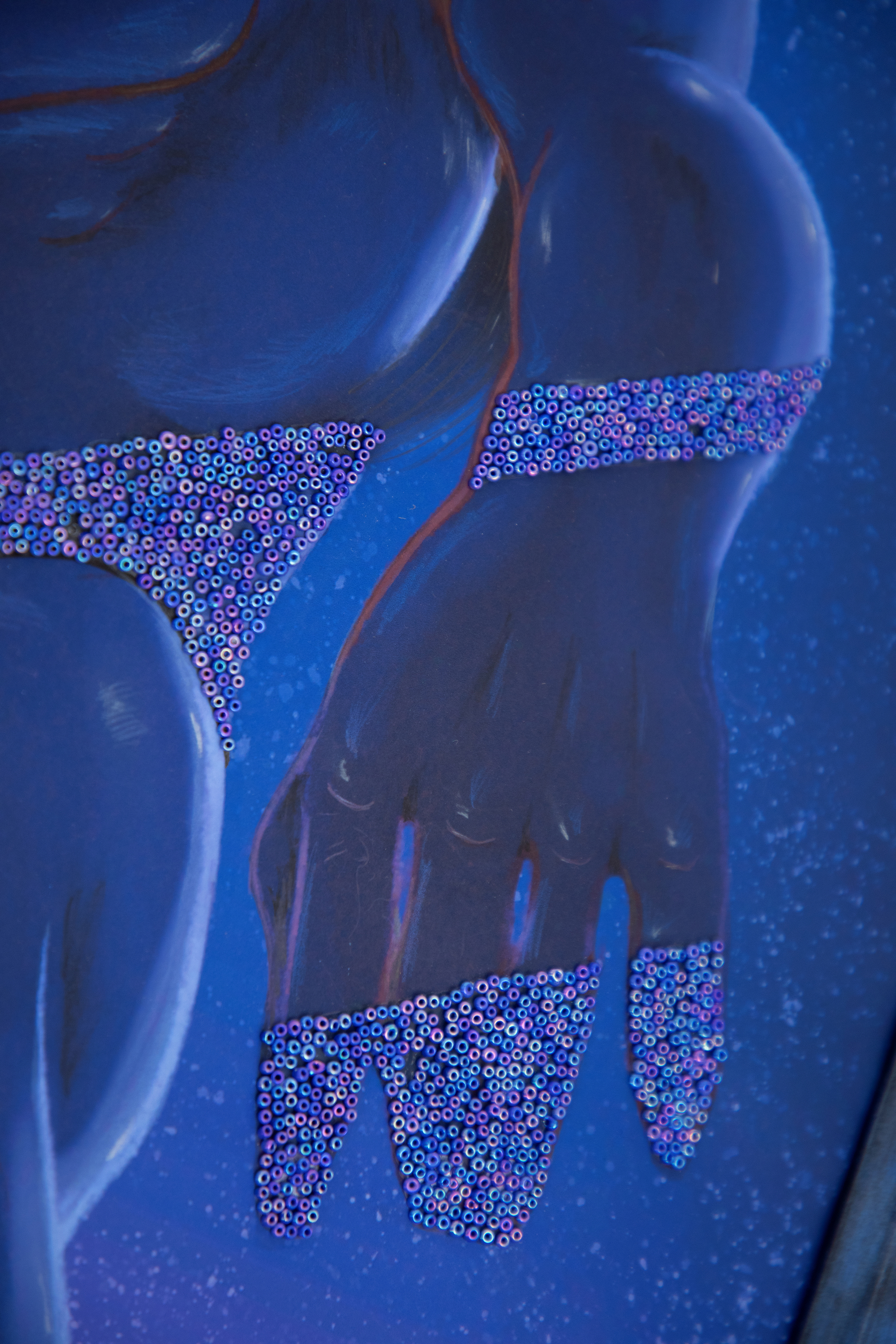 Detail of the figure's hand with beaded detail running across his fingers